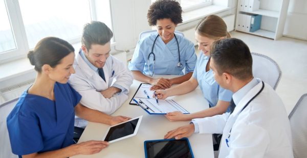 hospital, medical education, health care, people and medicine concept - group of happy doctors with tablet pc computers meeting at medical office